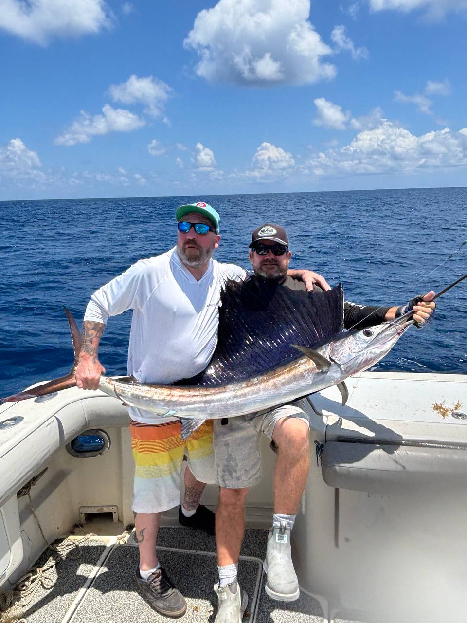 Two anglers posing with a sailfish release aboard Miss Penny in Islamorada